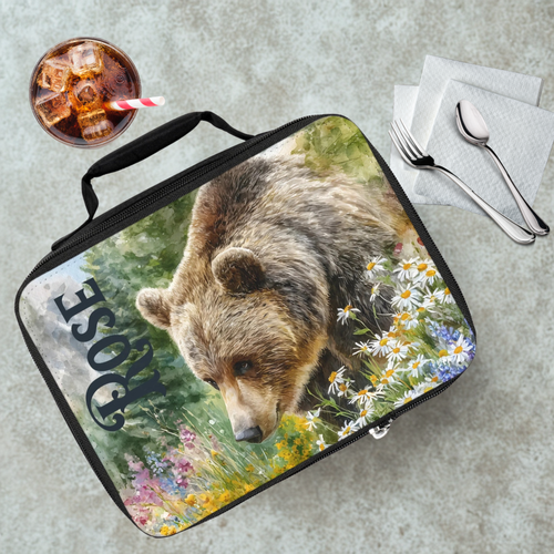Lunch bag with bear design and 'Rose' custom name on a cafeteria table with a drink and utensils.