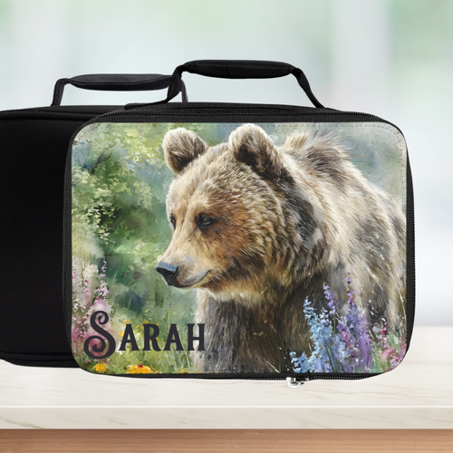 Black lunch bag with a bear design and 'Sarah' custom text on a blurred green background