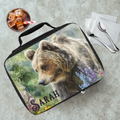 Lunch bag with bear design and 'Sarah' personalized text on a cafeteria table with a drink and utensils.