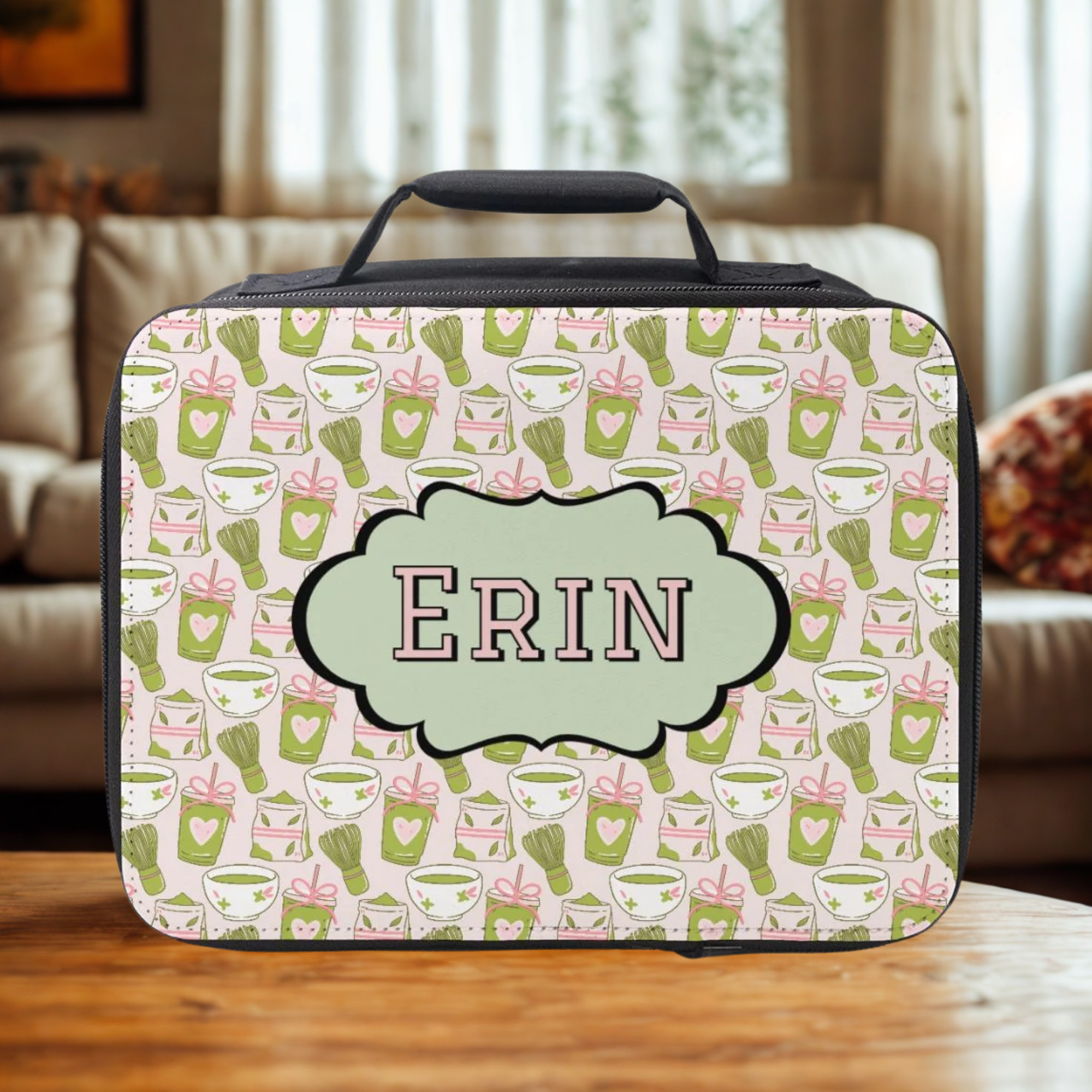  insulated lunch bag with green and pink matcha drink pattern and 'ERIN' personalized name on a wooden living room table.