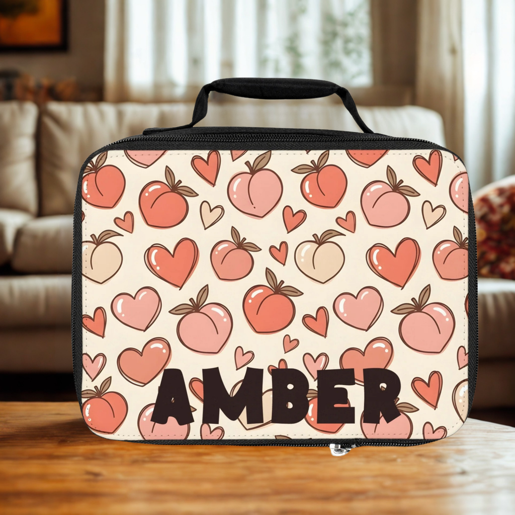  insulated lunch bag with peach and heart pattern and 'AMBER' personalized text on a wooden living room table.