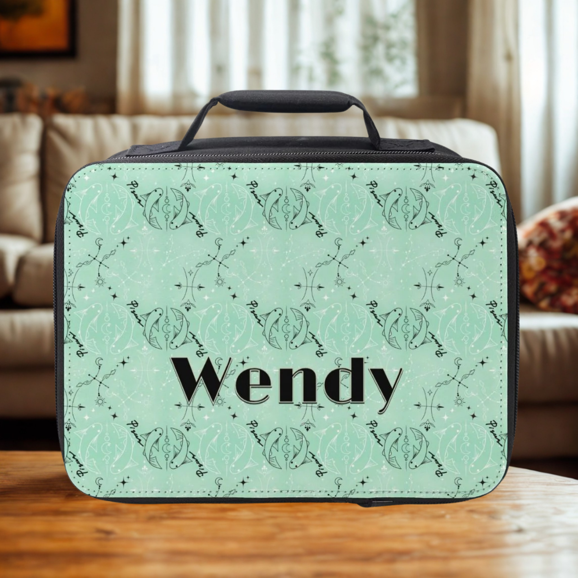 Green Pisces zodiac patterned lunch bag with 'Wendy' custom text on a wooden coffee table in a cozy living room.