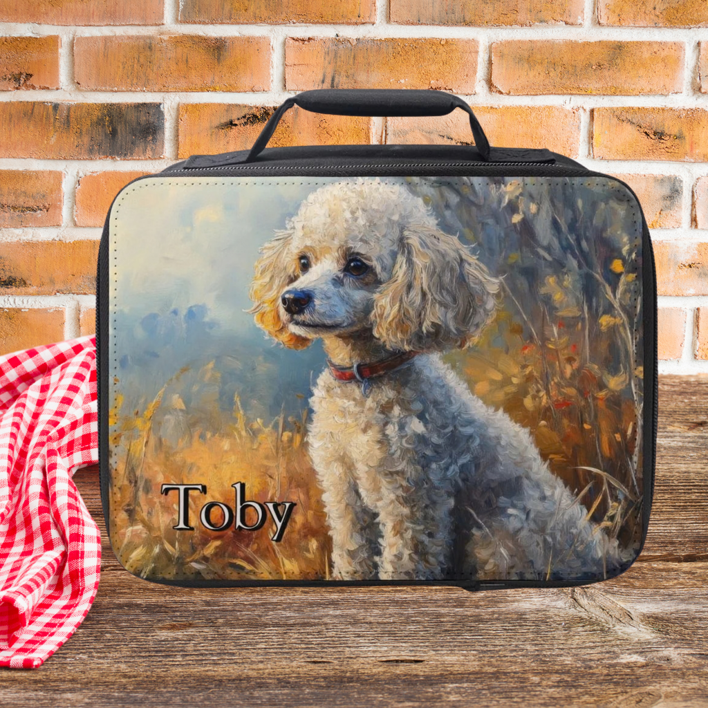  insulated lunch bag with a dog design and 'Toby' custom text, placed on a wooden picnic table with a brick wall background.