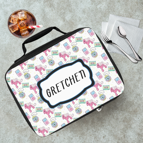 Lunch bag with colorful 90's pattern and 'Gretchen' custom text on a gray table with a drink and utensils.
