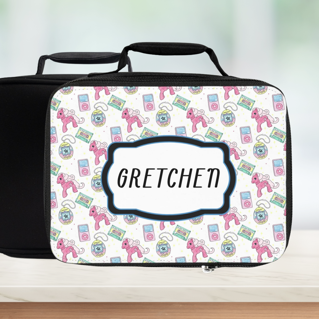 Lunch bag with colorful retro 90's pattern with and 'Gretchen' custom text on a counter with a blurred green background.