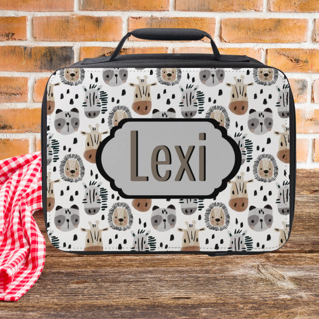 Lunch bag with animal pattern and 'Lexi' personalized text on a wooden surface with brick background