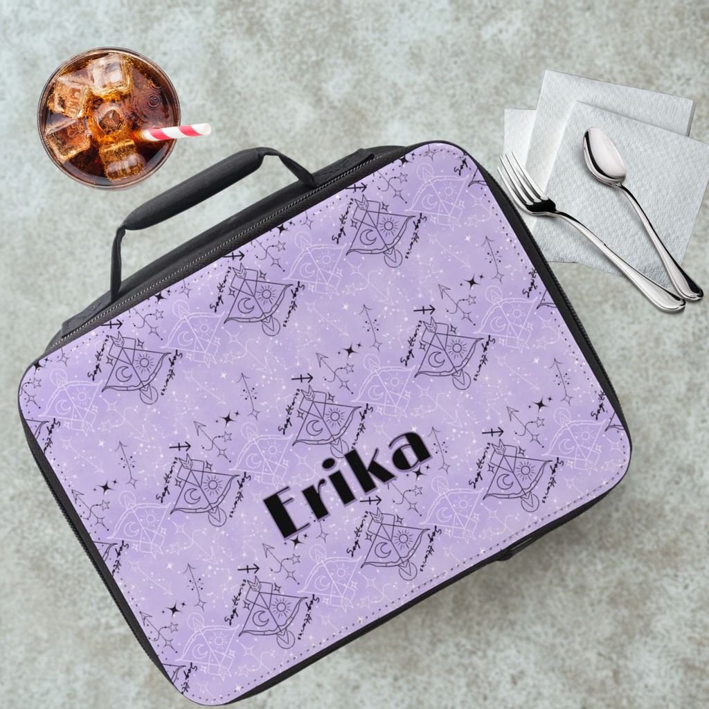 Purple and black lunch bag with 'Erika' printed on it, next to a drink and utensils on a gray table.