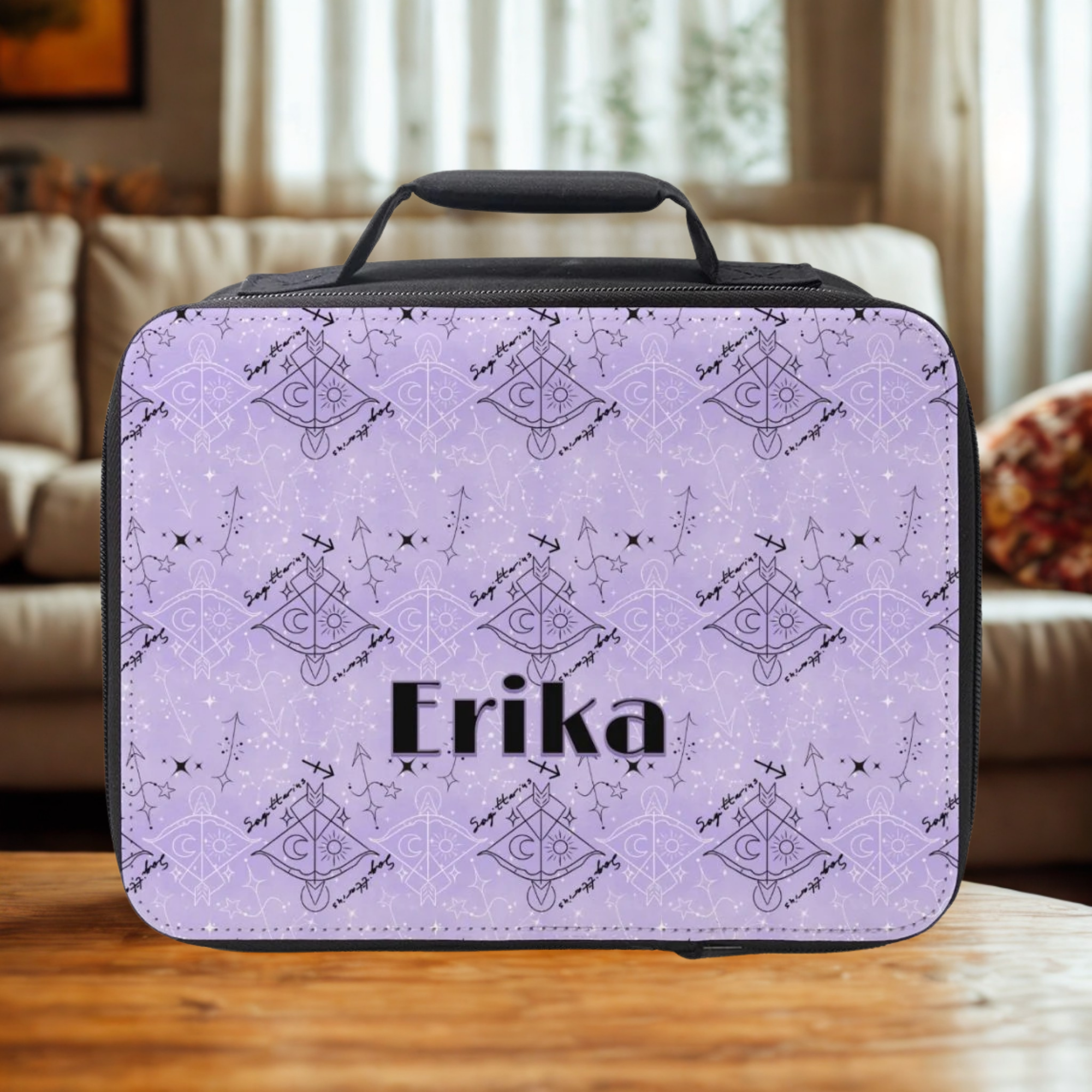 Lunch bag with black and purple Sagittarius zodiac pattern and 'Erika' custom text on a wooden coffee table in a living room.