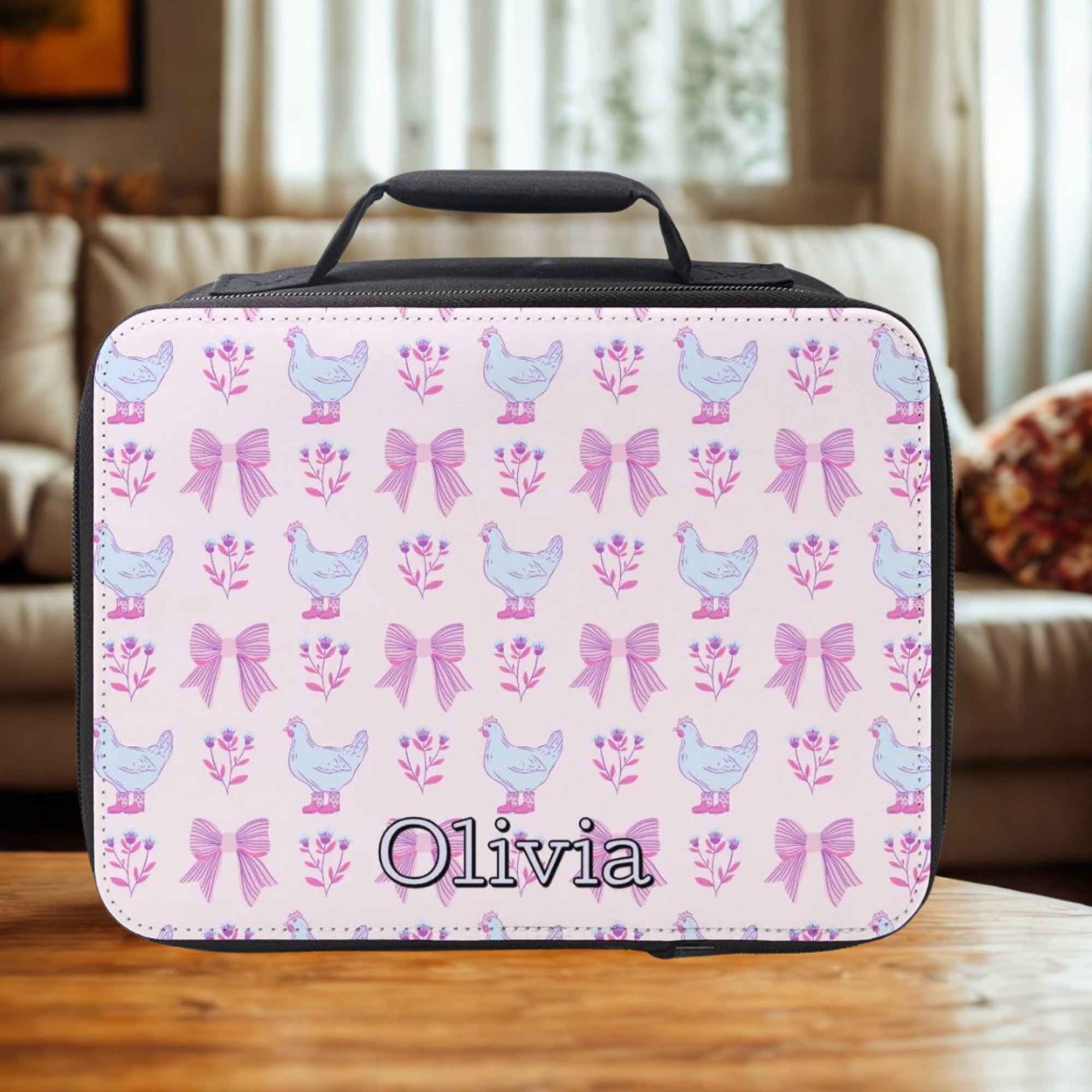 Personalized lunch bag with chicken and bow pattern on a wooden living room table.