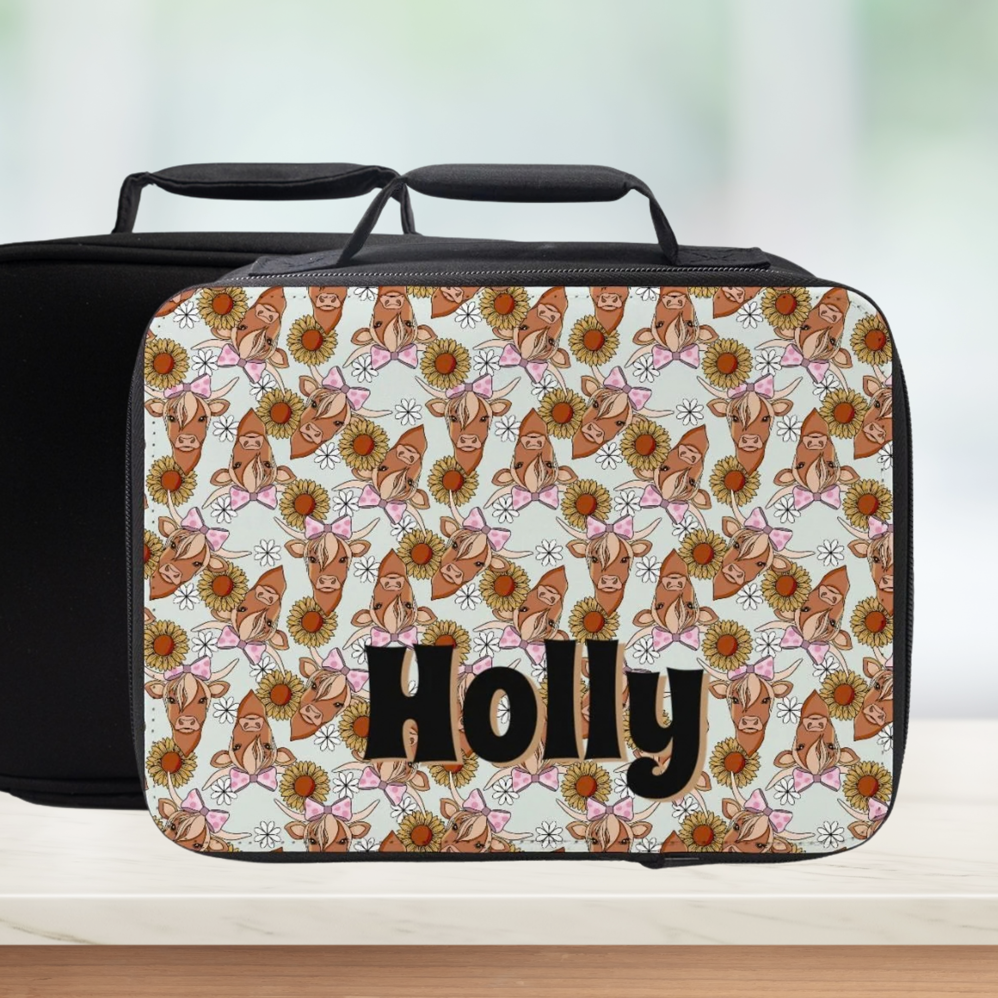 Lunch bag with highland cow pattern and 'Holly' custom text on a light background