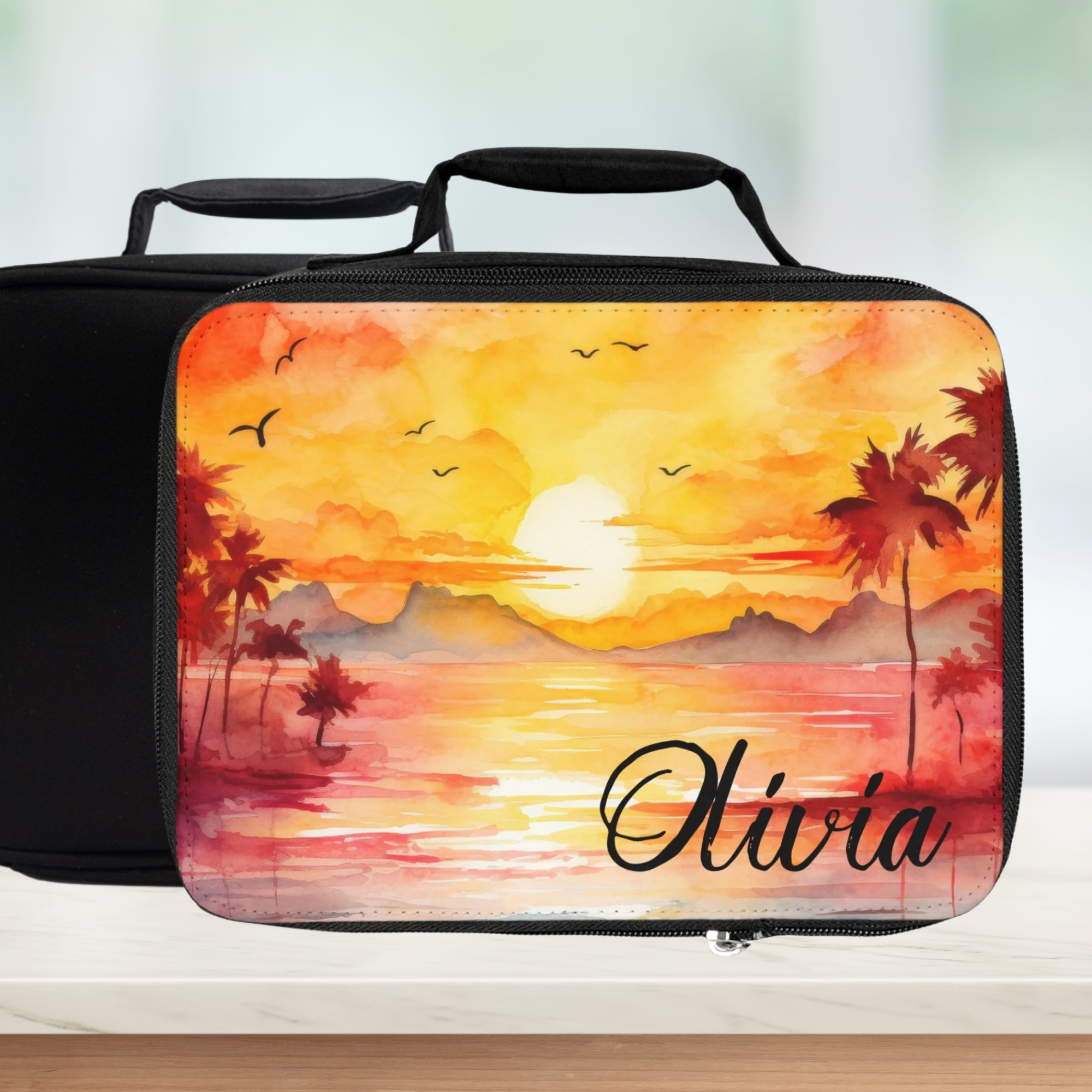 Personalized lunch bag with sunset design and name 'Olivia' on a blurred background