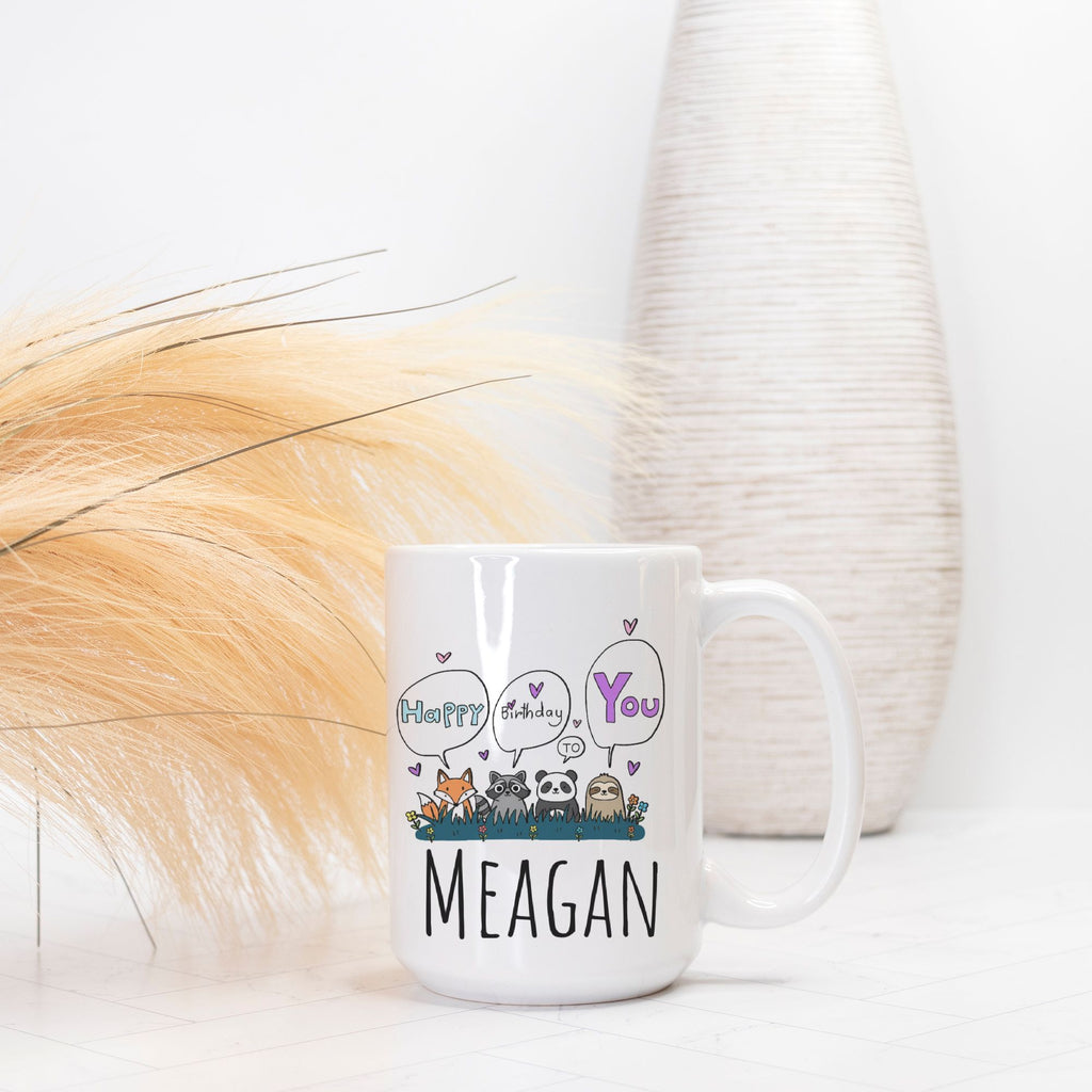 White mug with cartoon animals and text 'Happy Birthday You MEAGAN' on a white background