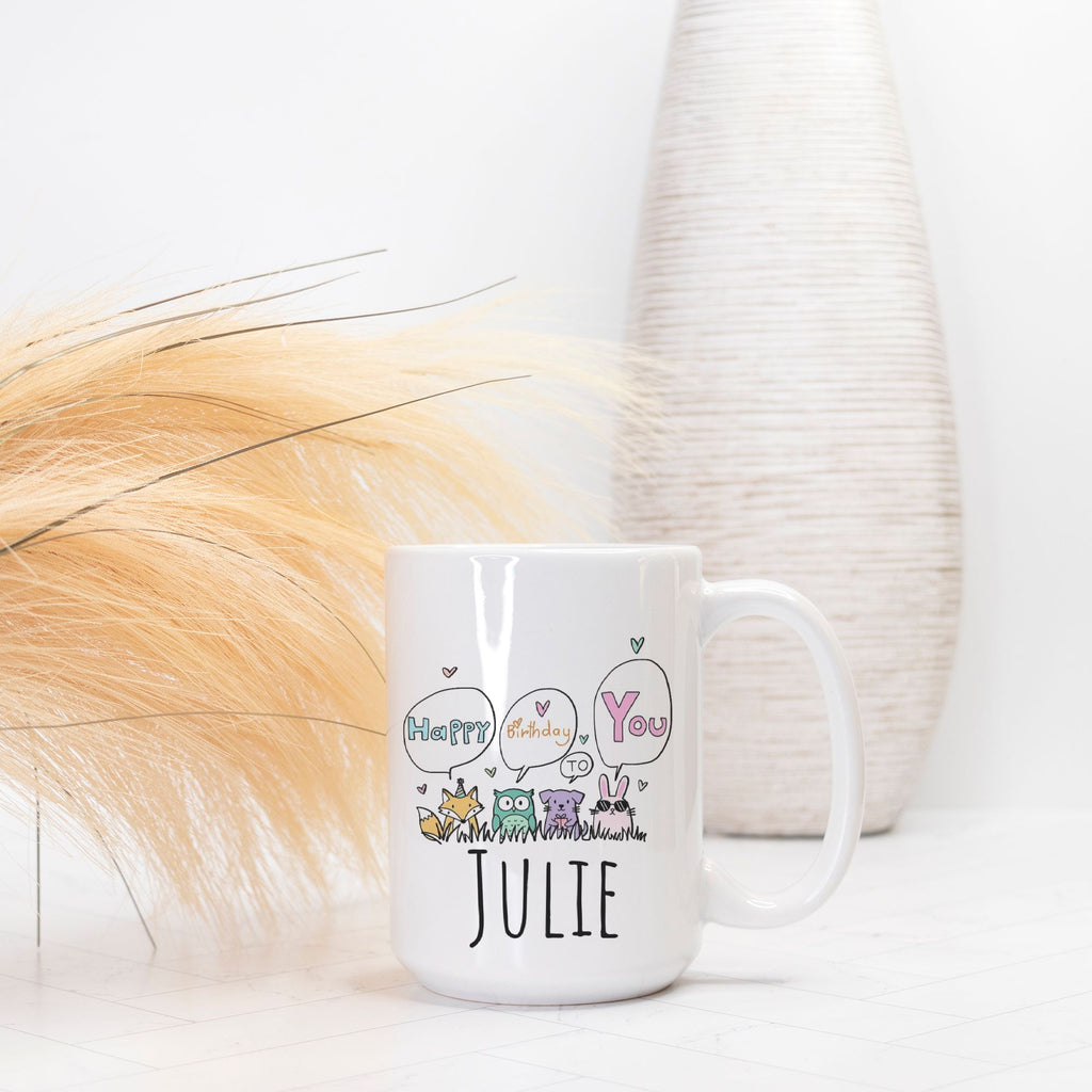 White mug with decorative text and baby animal illustrations on a light background