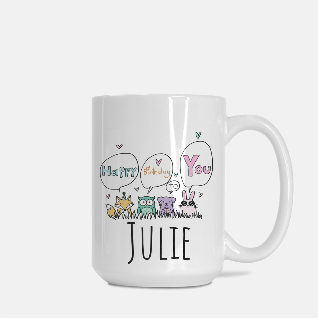 White mug with cartoon animals and text 'Happy Birthday You' to Julie on a white background