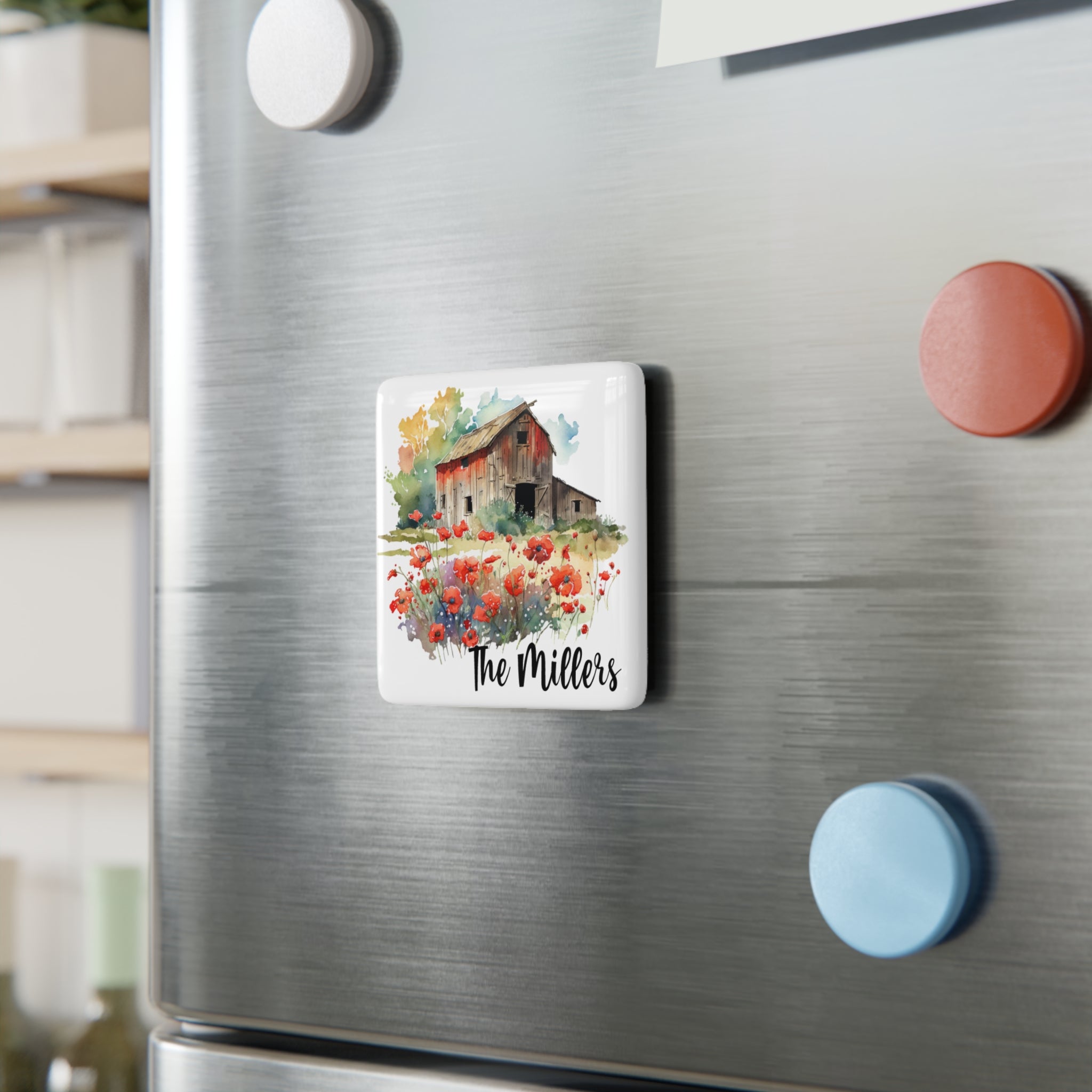 Fridge magnet with a red barn and flowers design on a metallic refrigerator.