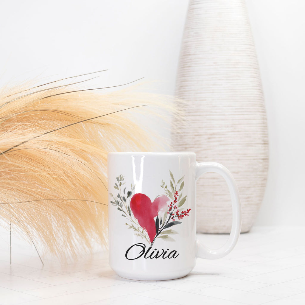 White mug with a heart and floral design, featuring the name 'Olivia', on a light background.