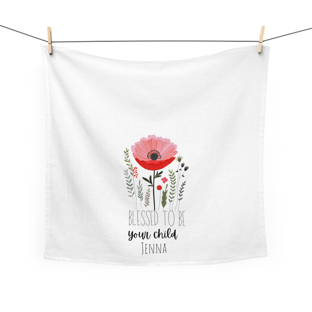 Hanging white tea towel with floral design and text on a white background