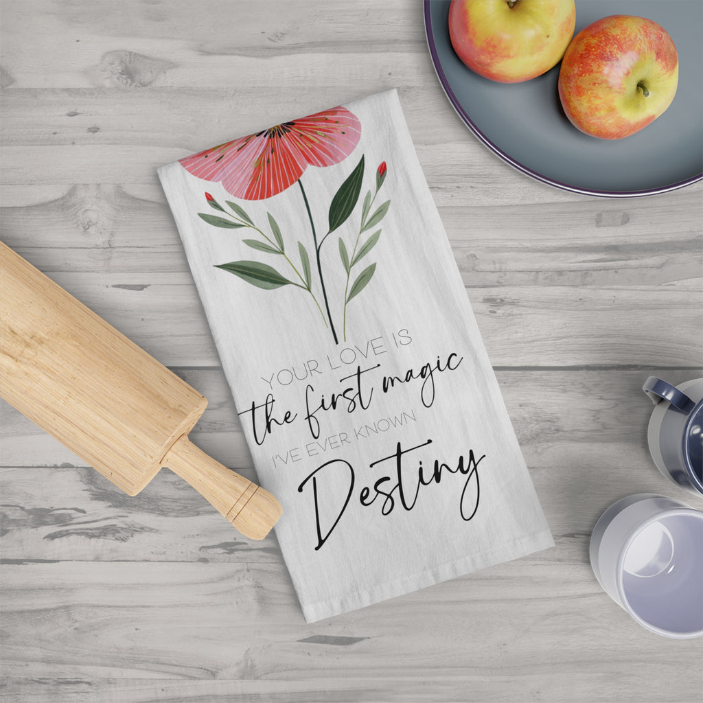 Floral designed kitchen towel with personalized text on a wooden surface with apples and a rolling pin.