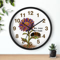 Black wall clock with a floral design and text on a white background