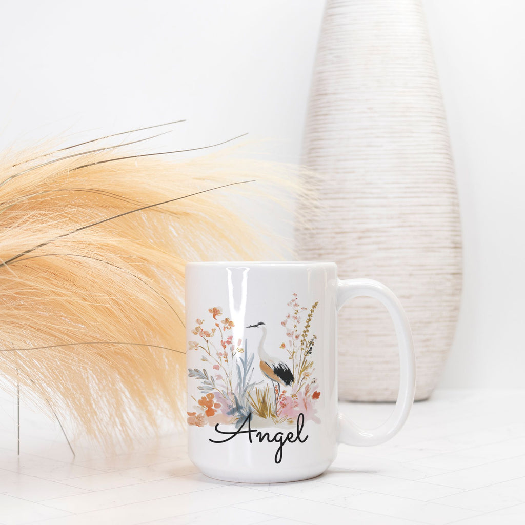 White mug with floral design and 'Angel' text on a white background