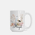 White mug with floral design and 'Angel' text on a white background