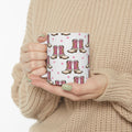 Person holding a mug with pink cowboy boot pattern