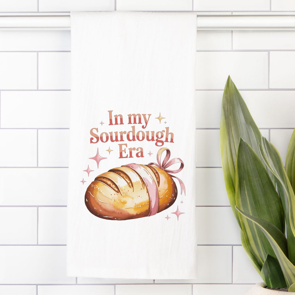 Tea towel with  a loaf of bread with 'In my Sourdough Era' text on a tiled wall.