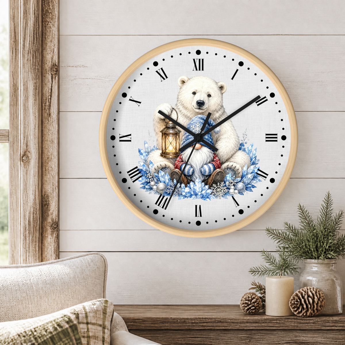 A round wall clock with a light wood frame hangs on a white shiplap wall above a rustic wooden table. The clock face features a white polar bear illustration holding a lantern and wrapped in blue floral garlands.