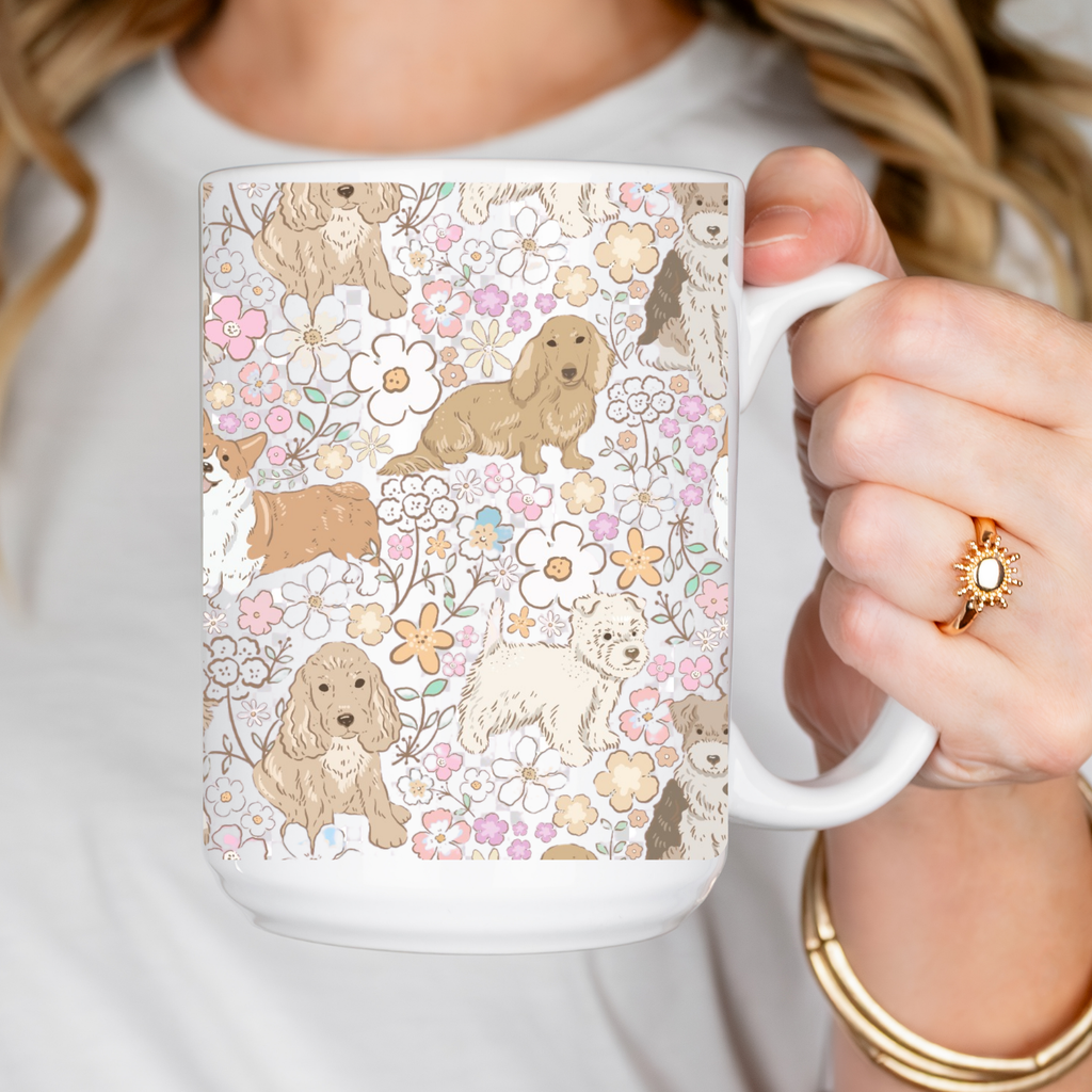 Person holding a mug with a floral and dog pattern