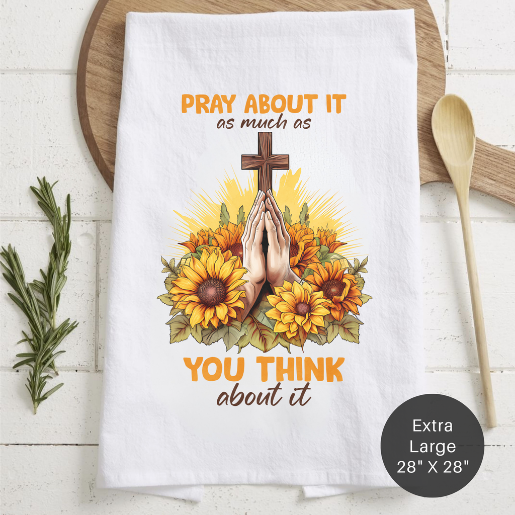 White tea towel with sunflower design and text on a wooden surface