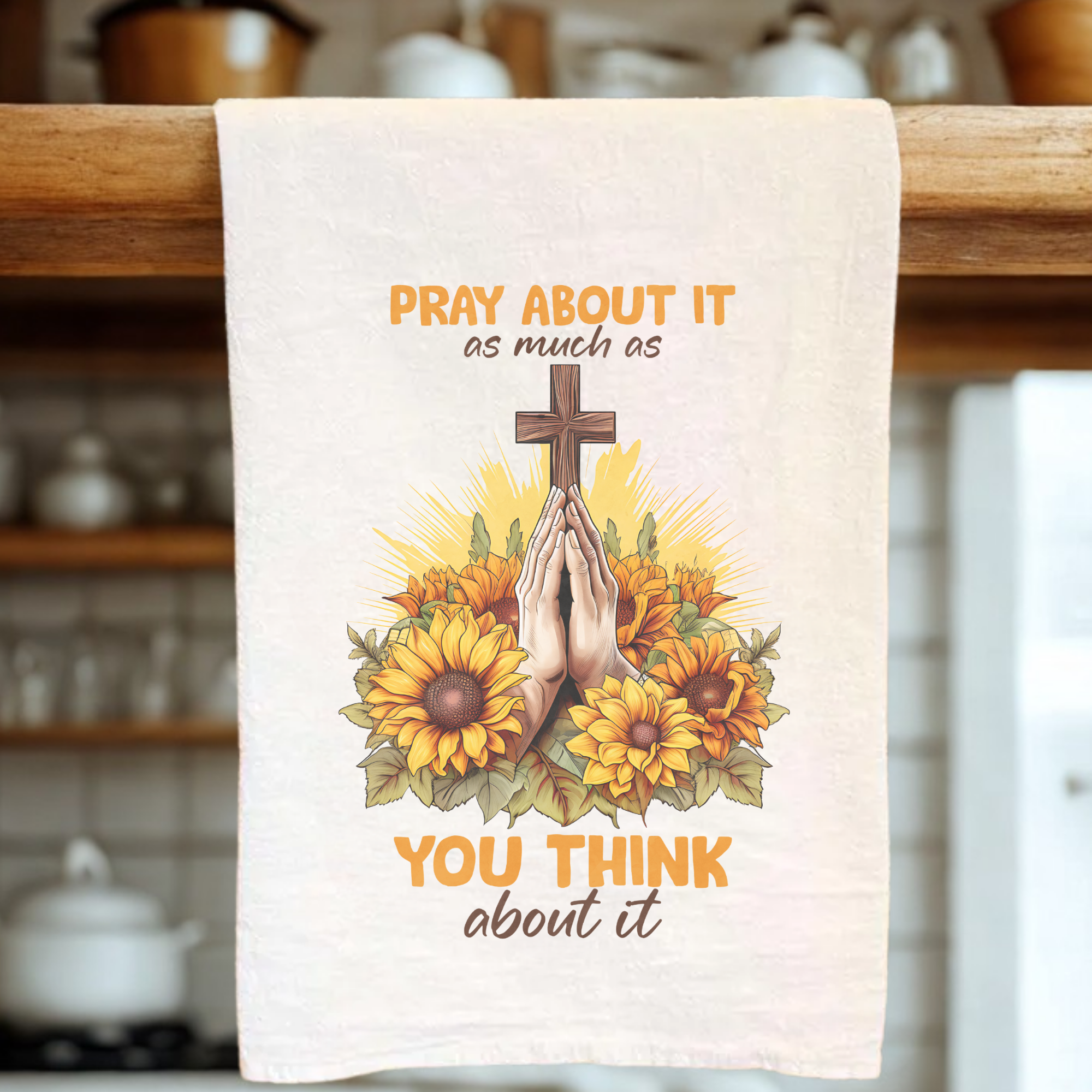 Tea towel with a cross, hands in prayer, and sunflowers design on a kitchen towel.