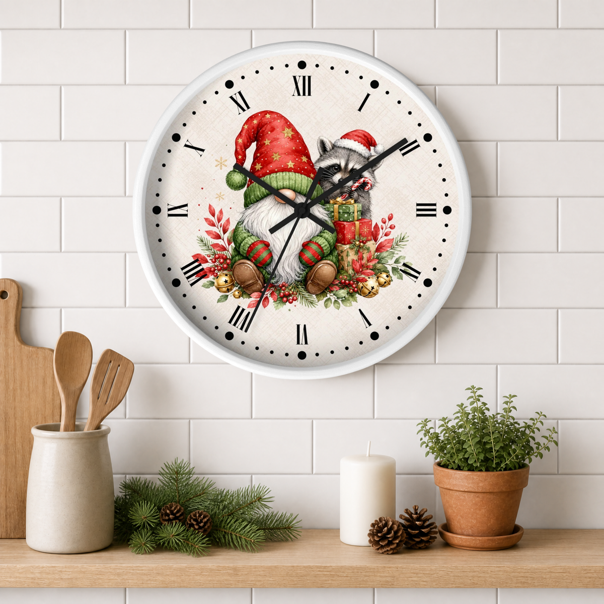 A round wall clock with a white face and black Roman numerals, featuring a festive Christmas gnome illustration with red Santa hats, green clothing, brown boots, and red berries. The clock is mounted on a white subway tile wall above a wooden shelf styled with kitchen utensils, a candle, pinecones, and a potted plant.