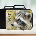 Black lunch bag with a raccoon design and 'LINDA' custom name on a blurred background