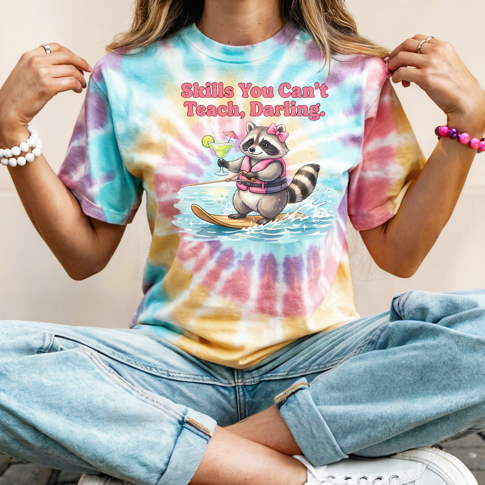 Person wearing a tie-dye t-shirt with a raccoon graphic and text.
