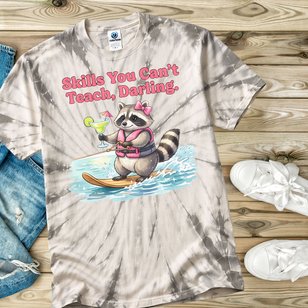 Tie-dye t-shirt with a raccoon graphic and text on a wooden surface.
