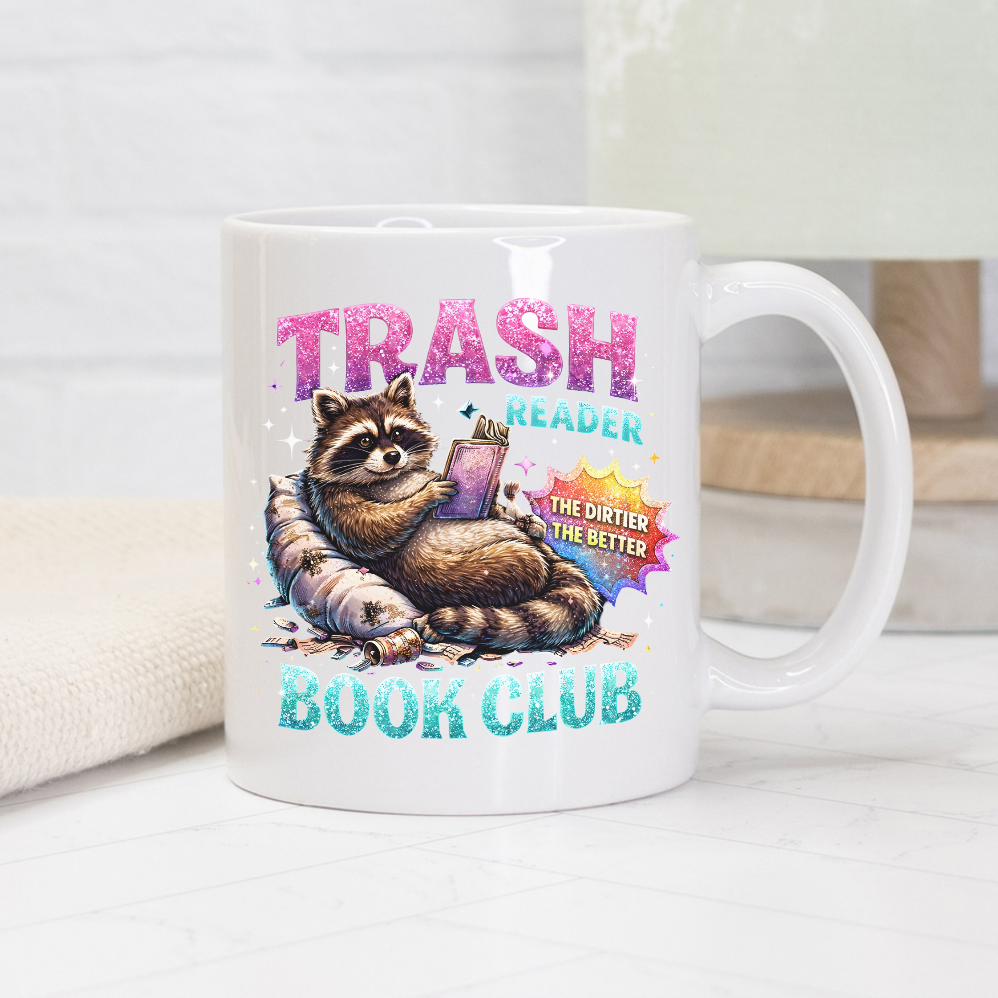 Mug with raccoon graphic and 'Trash Reader Book Club' text on a white surface.