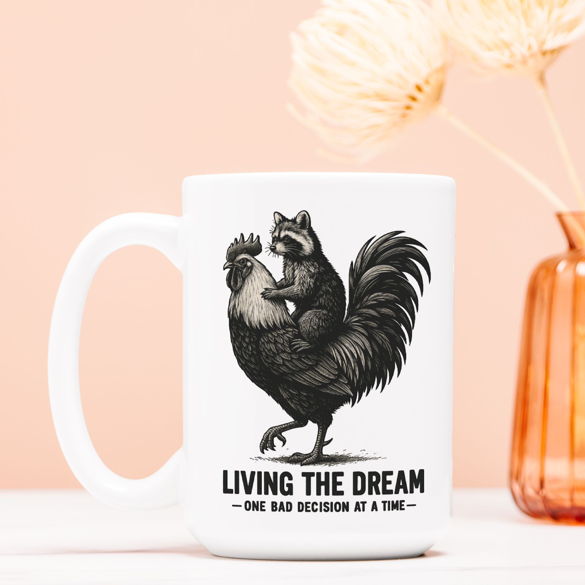 White mug with a black and white illustration of a raccoon on a rooster, with text 'Living the Dream - One Bad Decision at a Time' on a light pink background.