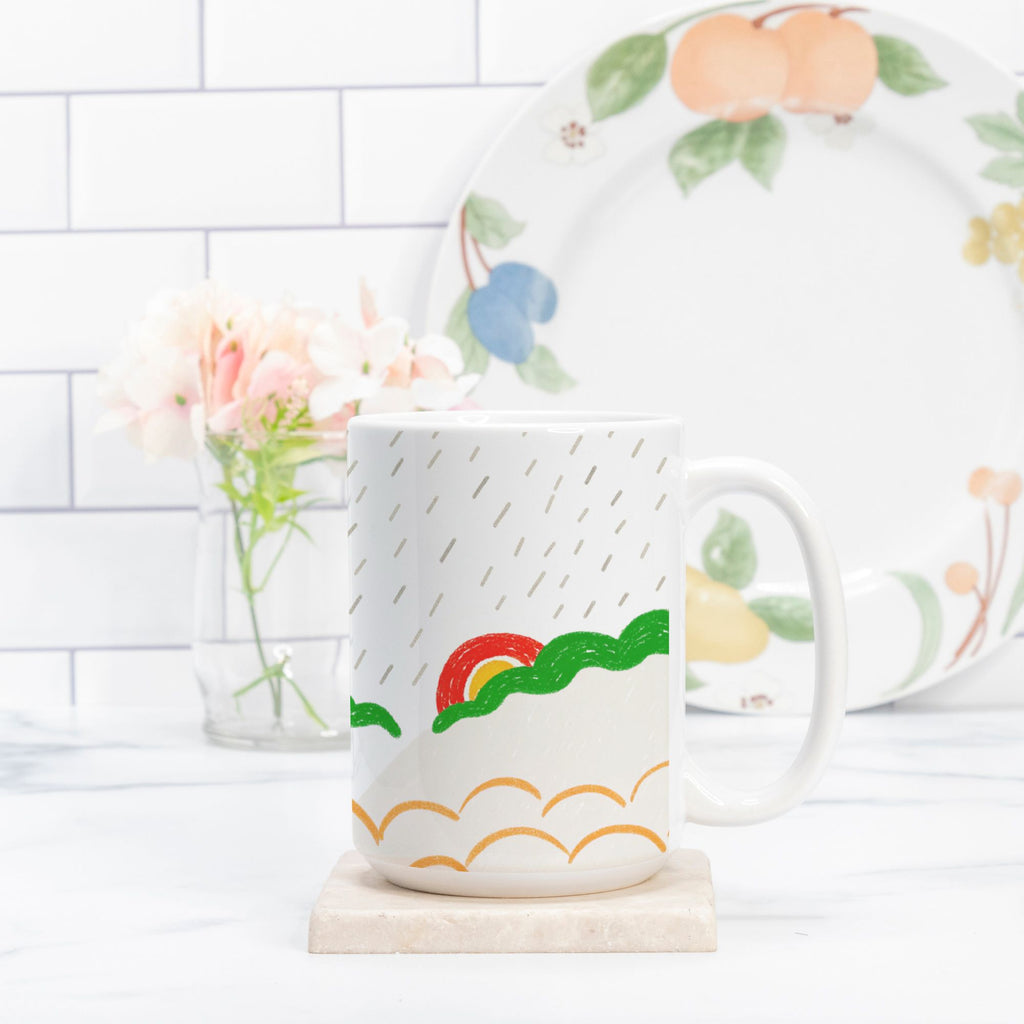 White mug with colorful design on a white surface with a blurred background
