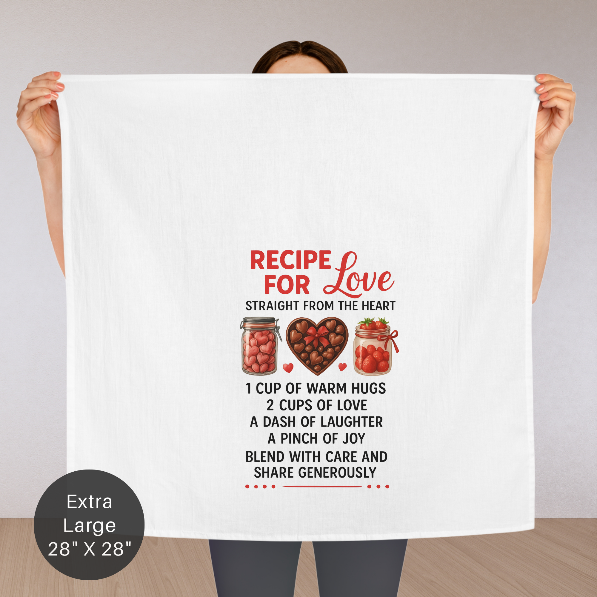 Person holding an extra large tea towel with 'Recipe for Love' text and graphics.