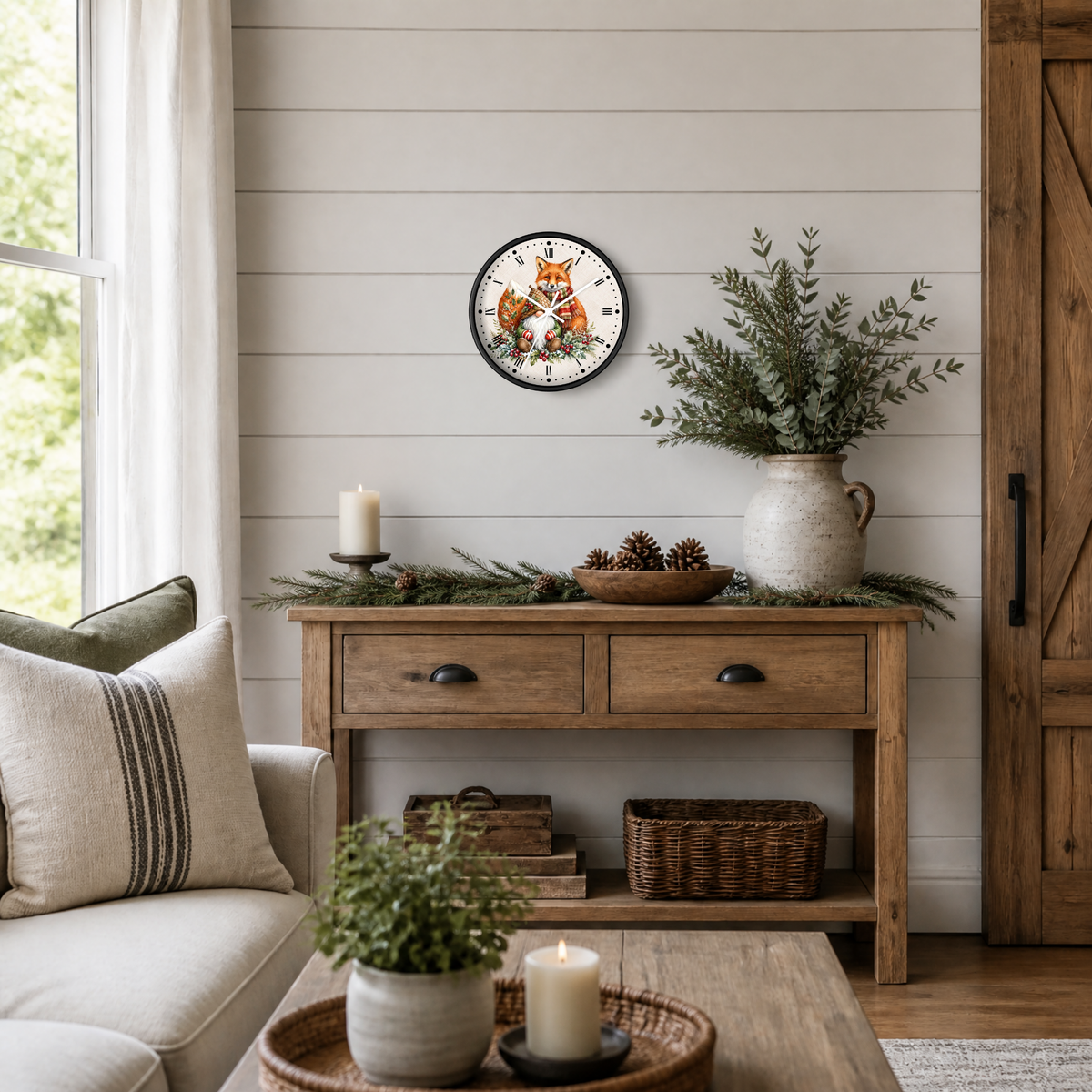 A round wall clock with a black frame and a festive Christmas design featuring a gnome & fox, displayed on a shiplap wall above a rustic wooden console table in a cozy living room setting.
