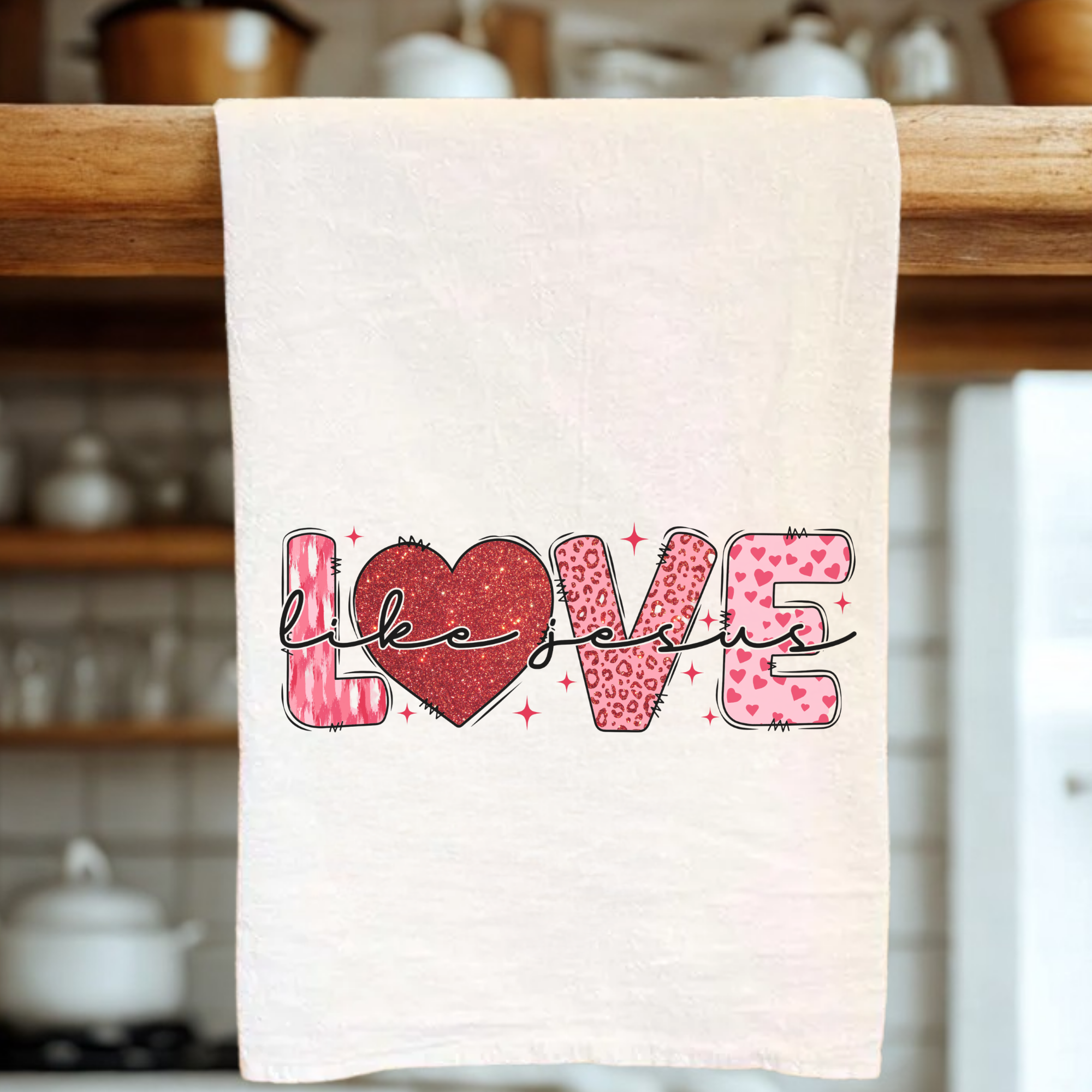Kitchen towel with 'LOVE' design hanging on a wooden rack.