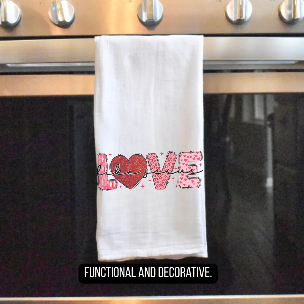 White tea towel with 'LOVE Like Jesus' design hanging on a stove handle