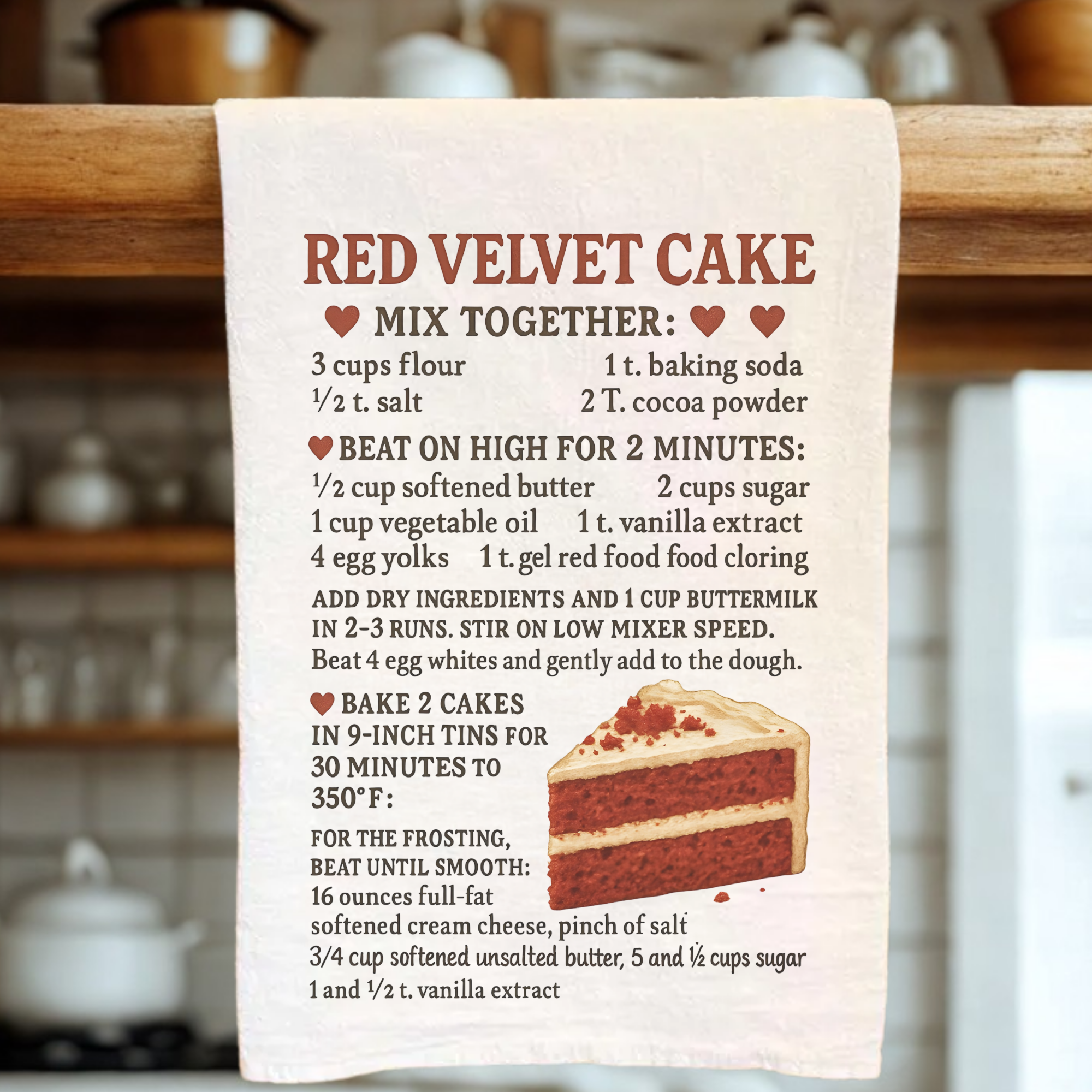 Red velvet cake recipe towel hanging on a wooden rack in a kitchen.