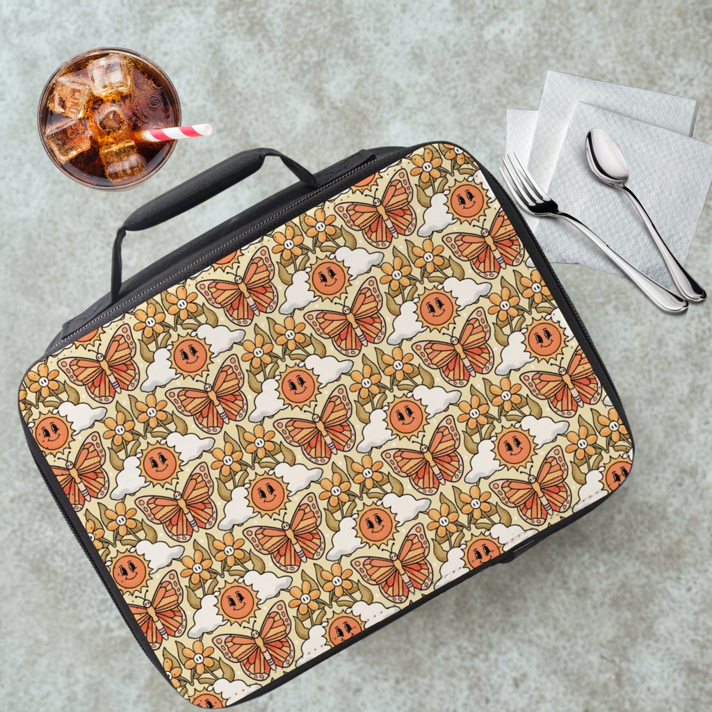 Patterned lunch bag with butterflies and flowers on a cafeteria table with a drink and utensils.