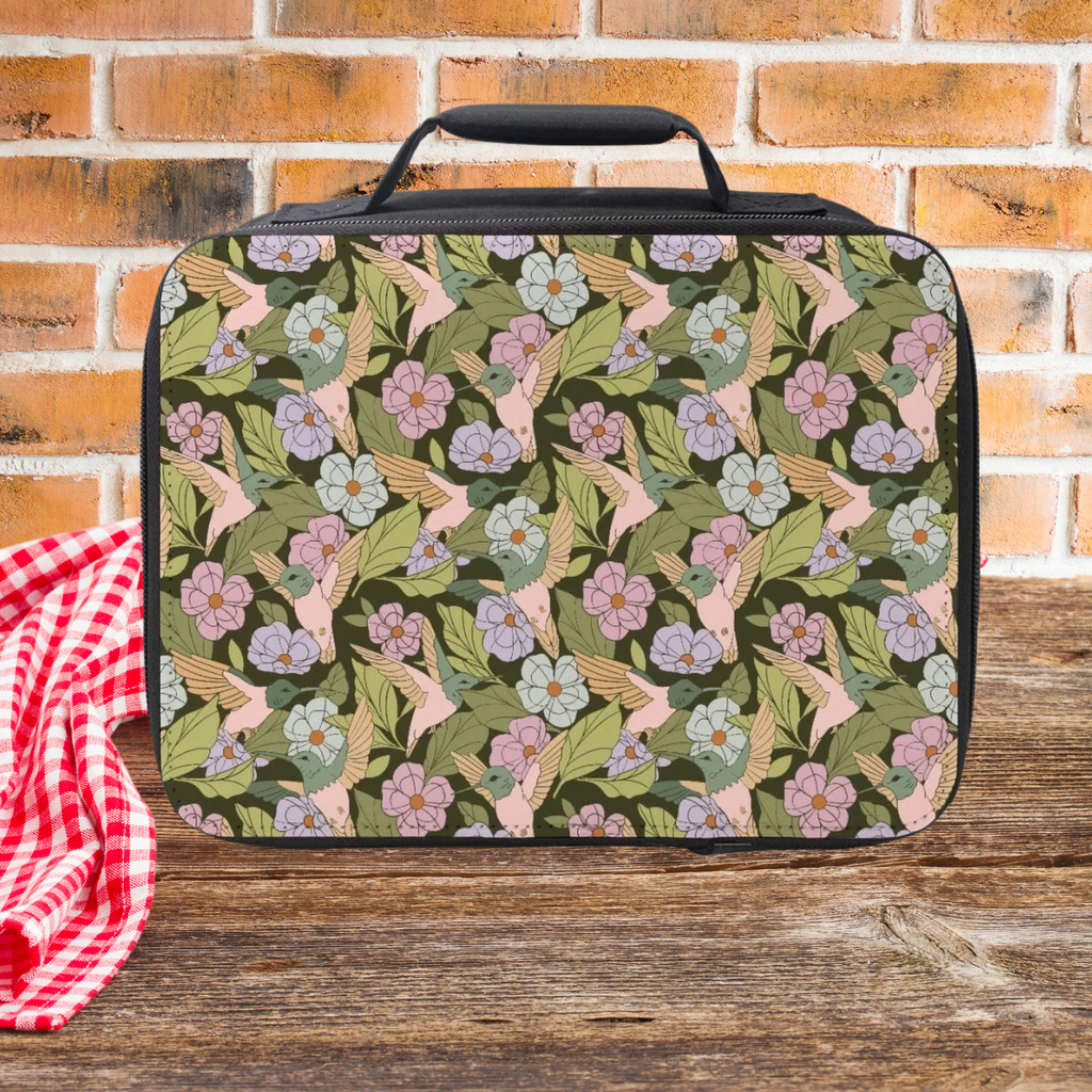 Floral and bird patterned lunch bag on a wooden picnic table with a brick wall background