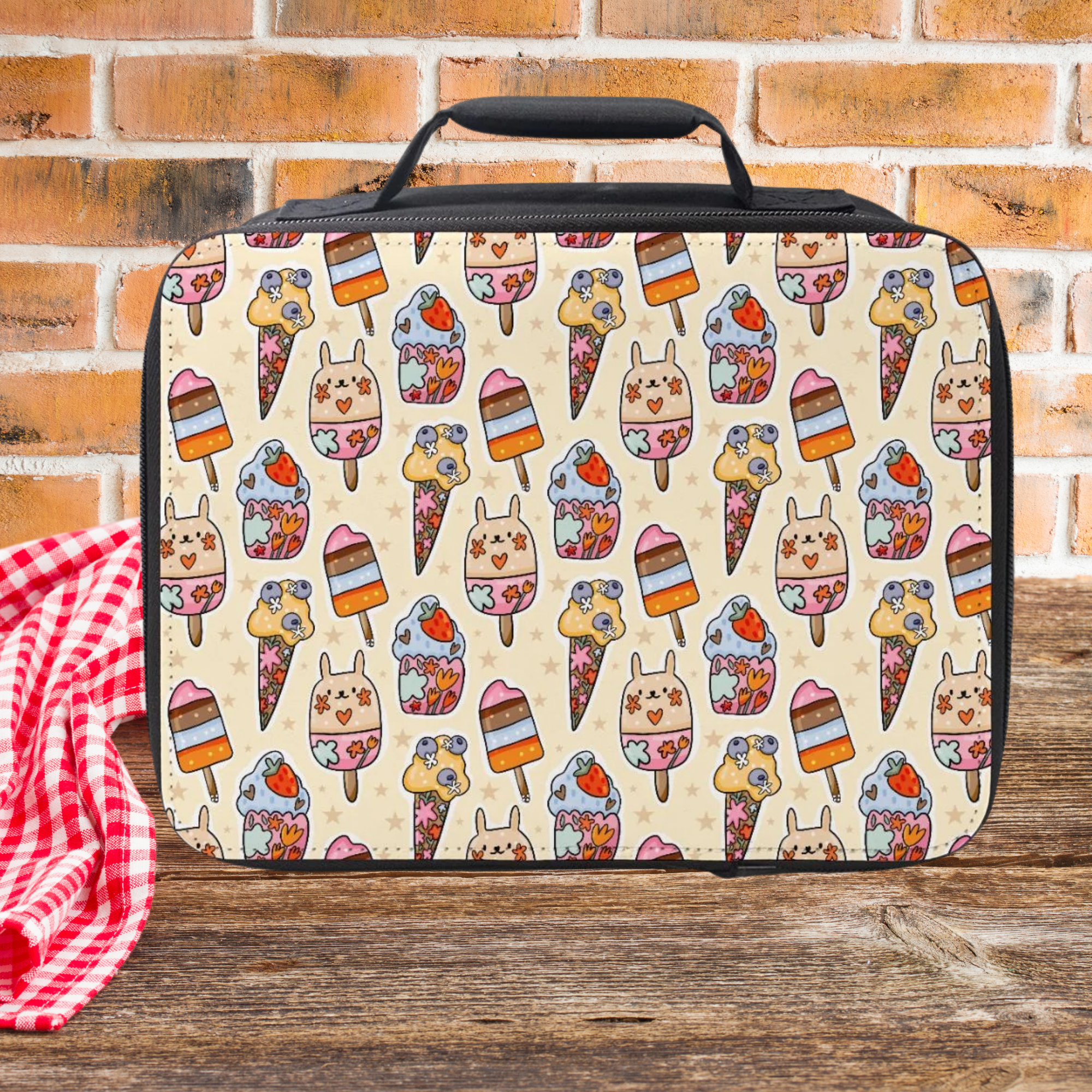 insulated lunch bag with ice cream pattern on a wooden picnic table and brick wall background