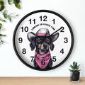 Wall clock with a dog illustration and 'Running on Doggie Time' text, placed on a surface with plants.