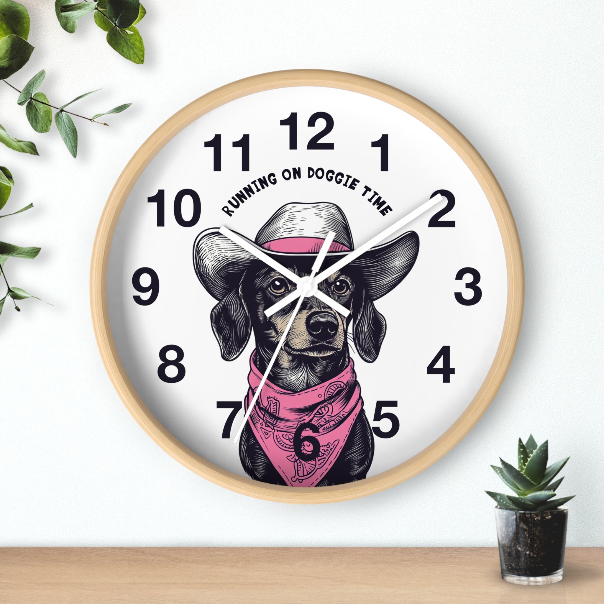 Wood wall clock with white hands and a dog illustration and 'Running on Doggie Time' text, placed on a surface with plants.