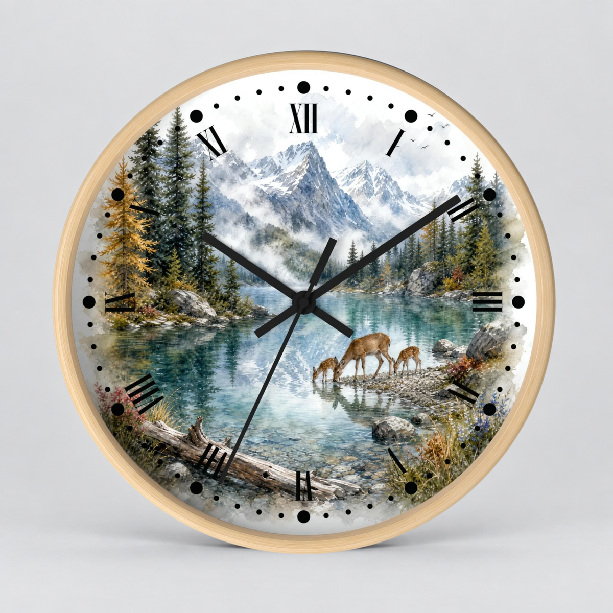 Round wall clock with a light wood frame and a scenic landscape print featuring mountains, a lake, pine trees, and deer, shown on a light gray background.