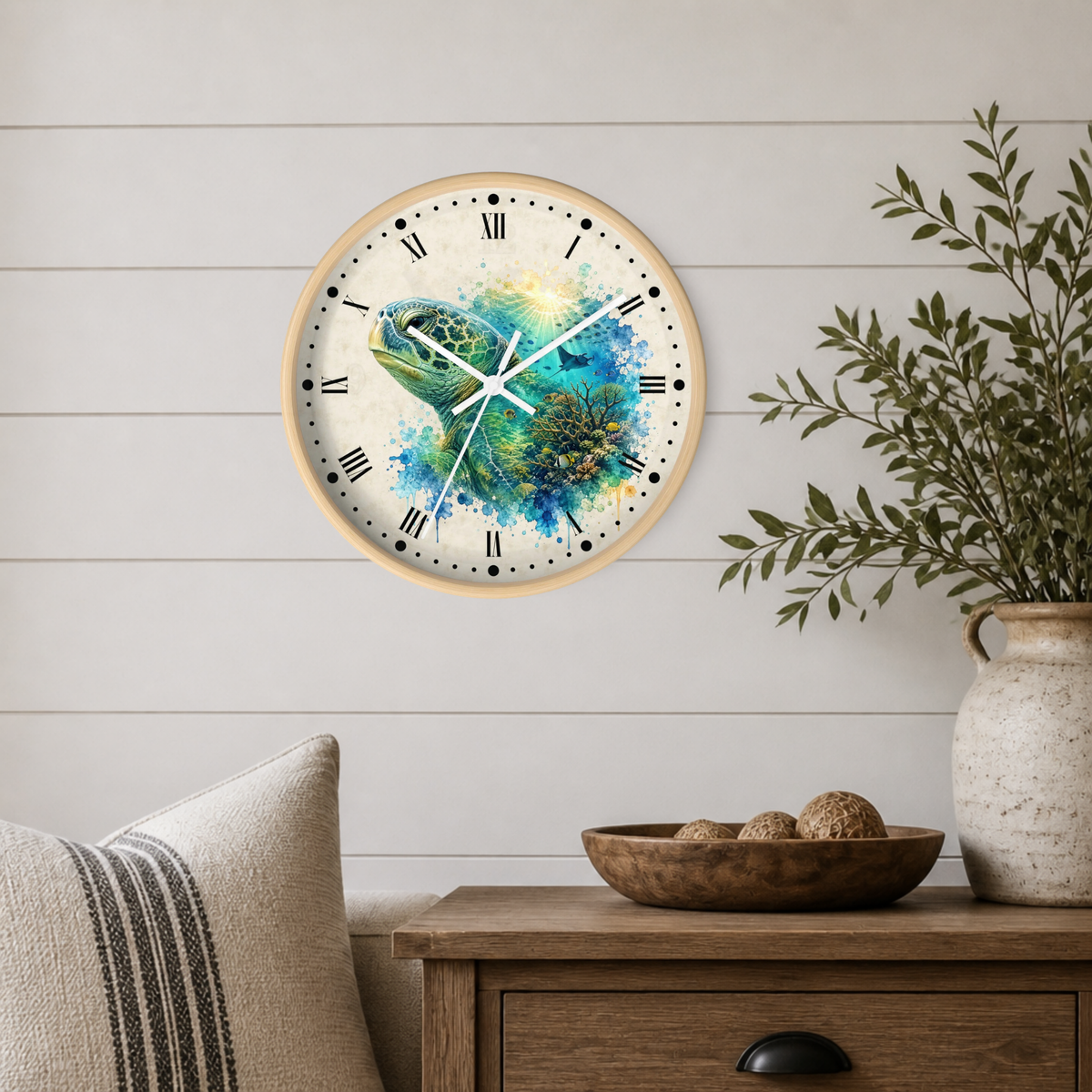 A round wall clock with a light wood frame and a colorful turtle illustration, mounted on a white shiplap wall above a wooden side table with a vase and bowl.